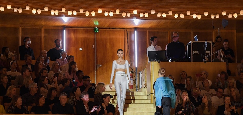 Desfile en la semana de la moda de Copenhage De París a Nueva York y de Nigeria a Bogotá: la moda desfila por el mundo París como sinónimo del lujo, Londres de la vanguardia, Nueva York imagen de la moda urbana y Milán reflejo del chic italiano. Las cuatro grandes pasarelas son las más consolidadas después de muchos años de recorrido, pero en los últimos años ciudades como Copenhague, Bogotá o Síd-ney han puesto en marcha eventos que prometen convertirse en el impulsor de las nuevas pro-mesas del diseño en el mundo. Las pasarelas empezaron al inicio del siglo XX como un ejercicio formal, con el objetivo de mos-trar a los clientes selectos de una marca las últimas novedades para que, posteriormente, ellos hicieran un pedido de los modelos deseados. A partir de los cincuenta, las pasarelas comenzaron a convertirse en una estrategia de márketing, y en los noventa tuvieron su boom y se convirtie-ron en mainstream con la llegada de las supermodelos. En la actualidad, las pasarelas viven un momento de transición y una crisis de identidad. Según Pedro Mansilla, experto en el sector, “el modelo está agotado”. “Las pasarelas son muy caras (la organización de un desfile puede costar entre 50.000 euros y cinco millones de euros) y con las redes sociales ha perdido el eje”, explica el experto. Según Mansilla, los desfiles sólo tienen sen-tido para aquellas marcas que ya están consolidadas, como Chanel, o para las emergentes que quieren conseguir atención mediática. Con todo, los pesos pesados del sector continúan subiéndose a las pasarelas para presentar sus colecciones de cada temporada. Desde París a Nueva York y de Nigeria a Bogotá, cada pasarela tiene sus rasgos identificativos que también definen a las marcas que desfilan en ellas. ¿Cuáles son hoy los valores más consolidados y los nombres emergentes del atlas global de los desfiles de moda? FOTO París, el guardián del lujo La semana de la moda de París continúa teniendo su papel predominante y de referencia. Es la más importante, la que marca el calendario internacional y la que genera un mayor impacto eco-nómico, de alrededor 1.200 millones de euros anuales, según la organización Fédèration de la Haute Couture et de la Mode, impulsora del evento. Por la pasarela de la capital francesa desfilan las marcas de mayor renombre, como Chanel, Dior, Givenchy, Valentino o Maison Margiela. Para formar parte del calendario oficial de la semana de la moda de París, que tiene lugar dos veces al año, es necesario el cumplimiento de una serie de rigurosas normas. Cada empresa que quiera desfilar debe organizar showrooms privados en París, poseer un taller con al menos quince trabajadores y presentar una colección compuesta por al menos 35 outfits. Sin embargo, la Fédèration de la Haute Couture et de la Mode invita en cada edición a nuevas compañías a participar en la semana de la moda de París, aunque no cumplen con todos los re-quisitos. En los últimos años se han subido a la pasarela de la capital francesa compañías españo-las como Oteyza, Yolancris o Palomo Spain. Foto Londres, sinónimo de vanguardia Organizada por el British Fashion Council, la semana de la moda de Londres es otra de las más importantes del calendario internacional. Su rasgo definitorio es el de la vanguardia ya que es el evento que más novedades acoge de todos los que se celebran en el mundo. Nombres como Burberry, Christopher Kane, JW Anderson, Mulberry, Tommy Hilfiguer, Victoria Beckham o Viviene Westwood son algunos de los más reconocidos entre los 150 que desfilan durante la jornada y que generan un impacto de 269 millones de euros, según la organización. “Está empezando a coger más peso”, explica Pepa Bueno, directora ejecutiva de la Asociación de Creadores de Moda de España. Recientemente, la pasarela ha dado un paso más allá en inno-vación anunciando la creación de un programa de eventos paralelos a los desfiles con el objetivo de abrir la pasarela al público final. Foto Milán, abanderada del ‘made in Italy’ El lujo italiano como símbolo de diferenciación. La Canera Bazionale della Moda Italiana ha conse-guido hacer de la semana de la moda de Milán un referente y le ha encontrado un hueco propio en el calendario internacional. El evento genera un impacto económico de casi doscientos millo-nes de euros en cada edición, según la organización. Con Gucci, Versace, Dolce&Gabbana, Salvatore Ferragamo, Giorgio Armani, Prada o Dsquared2 al frente, la semana de la moda de Milán se ha convertido en símbolo del lujo italiano, más opu-lento que el francés. En los últimos años, con el boom de diseñadores que conquistan a las masas como Alessandro Michele o Jeremy Scott, la semana de la moda de Milán ha conseguido mantener su liderazgo como una de las más importantes del calendario internacional con la participación de más de 250 empresas. Foto Nueva York, imagen de la moda urbana “Menos fantasía y creatividad y más conexión con el prêt-á-porter”, según Bueno, estos son los rasgos identitarios de la semana de la moda de Nueva York, impulsada por el Council of Fashion Designers of America (Cfda). Según la organización, el impacto económico de este evento se estima en 887 millones de dólares. Sin embargo, aunque la pasarela de la Gran Manzana es sinónimo de modernidad y todo lo que tiene que ver con lo cool, en los últimos años ha perdido peso. “Se encuentra en un momento difícil”, señala Bueno. Actualmente, el evento está centrado en reactivar el atractivo que en su día instauraron Calvin Klein, Marc Jacobs o Rodarte. Pesos pesados como Tommy Hilfiguer, Thom Browne, Proenza Schouler o Rodarte se han bajado en los últimos años de la pasarela de Nueva York. El último en exiliarse ha sido Tom Ford (presi-dente de la Cfda) que ha decidido desfilar en Los Ángeles, pasarela que cada vez gana más peso y se aprovecha de la convocatoria de las celebrities a la gala de los Oscars para atraer al público de élite. Más allá de las big four de las pasarelas internacionales, en los últimos años han ganado peso eventos emergentes que combinan nuevos formatos y apuestan por tendencias como la soste-nibilidad o abrir sus puertas al consumidor final, además de ser el escaparate de los diseñadores del futuro. FOTO Copenhague, el auge de lo ‘eco’ “Es interesante cómo ha conseguido aunar toda la moda escandinava”, señala Pepa Bueno sobre la semana de la moda de Copenhague. La capital de Dinamarca ha consolidado el evento como una apuesta más vanguardista centrada en la sostenibilidad. De hecho, según la experta, al contrario que otros eventos, los desfiles de la semana de la mo-da de Copenhague sirven de acompañamiento a la jornada principal, que es el Copenhagen Fashion Summit, un evento que reúne a los principales operadores y voces del sector para deba-tir sobre el papel de la industria de la moda ante el cambio climático. Ganni, By Malene Birger y Baum und Pferdgarten son algunas de las compañías que participan durante el evento, que está impulsado por el Ministerio de Industria Negocios y Asuntos Finan-cieros de Dinamarca. FOTO Nigeria, la cuna del diseño emergente La semana de la moda de Lagos, puesta en marcha en 2011 por Omoyemi Akerele, es uno de los eventos que más se ha consolidado en el panorama internacional de pasarelas y el máximo ex-ponente de la moda africana. El objetivo de la semana de la moda de Lagos, además de la presentación de las colecciones de los diseñadores más importantes de la región, es dar impulso y fortalecer la industria africana de la moda. Más allá de los desfiles, el evento también cuenta con dos plataformas para fortalecer la indus-tria: Fashion Business Series y Fashion Focus, que ofrece clases magistrales y brinda apoyo a las marcas emergentes del sector en la región. FOTO Tbilisi, centro de la moda caucásica La capital de Georgia también se ha convertido en una de las principales pasarelas de moda emergente. Impulsada por Mercedes Benz en 2009, la pasarela ganó notoriedad al ser el hogar de Demna Gvsalia, fundador de Vetements y actual director creativo de Balenciaga. Durante la jornada, que se celebra dos veces al año, participan más de setenta diseñadores de la región. El ‘momentum’ de Bogotá “Creo que Colombia se está convirtiendo en un punto focal en la región gracias al reconocimiento universal, ahora los compradores internacionales quieren venir a las pasarelas del país a ver que está pasando en la industria”, señala Diana Hochman, del equipo de Bogotá Fashion Week. Con la Cámara de Comercio de Bogotá al frente, la semana de la moda de la capital colombiana también cuenta con talleres educativos y un programa de acompañamiento para los diseñado-res emergentes de la región. En la pasarela desfilan alrededor de 135 marcas. FOTO Shanghái y Sídney, las joyas del Pacífico Asia también alberga a varias pasarelas internacionales que han ganado peso en los últimos años. Es el caso de la semana de la moda de Shanghái, Mode Shanghai Apparel Exhibition, impulsada desde 2013 por el Ministerio de Comercio de China. La jornada, además, se celebra de la mano de varias ferias internacionales y tiene como objeti-vo promover la mejora de la cadena de valor de la industria de la moda, a la vez que satisface las necesidades individuales del mercado minorista de moda nacional. En el evento participan dise-ñadores como Zhang N, Moti Bai, CJ Yao, Momo Wang o Nicole Zhang. Nacida en 1996 de la mano del ex reportero Simon Lock, la semana de la moda de Sídney se ha convertido en una de las más importantes del Pacífico, donde desfilan compañías como Lisa Ho, Alex Perry, Zimmermann, Toni Maticevski, Collette Dinnigan, Leona Edmiston , J'Aton Couture, Ericaamerica, Easton Pearson y Gwendolynne. Impulsada por el gigante International Management Group (IMG) y patrocinada por Mercedes Benz, el evento da especio a los diseñadores emergentes de la región. En su última edición, la pasarela decidió seguir los pasos de la semana de la moda de Londres y abrió sus puertas al públi-co final. En concreto, durante los cinco días de la jornada, la semana de la moda de Sídney reservó el 25% de los asientos a consumidores. Además, la entrada, cuyo precio ascendía a 119 dólares, también daba acceso al público final a seminarios y otros eventos especiales durante la jornada. FOTO Madrid, en busca de un discurso “Madrid necesita un discurso propio para ser reconocida”, explica Pepa Bueno. La Mercedes Benz Fashion Week Madrid, impulsada por Ifema, es uno de los eventos más reconocidos del sector de la moda en España. Actualmente, el evento se encuentra en la búsqueda de su propio espacio en el calendario, ya que, según Nuria de Miguel, al frente del evento “la pasarela de Madrid tiene vocación interna-cional”. En su última convocatoria participaron 37 diseñadores españoles como Ana Locking, Devo-ta&Lomba, The 2nd Skin Co, Agatha Ruiz de la Prada, Pedro del Hierro, Custo Barcelona, Angel Schelesser, Brain&Beast, Devota&Lomba, Andres Sardá o Juan Vidal, entre otros. La próxima edición de la pasarela tendrá lugar entre el 2 y el 7 de septiembre. Participar en la Mercedes Benz Fashion Week Madrid supone un coste de entre 6.000 y 15.000 euros para las compañías del sector, dependiendo si organizan sus desfiles en el recinto de Ifema o en otras ubicaciones como el Palacio de Cristal. El impacto económico de la jornada es de alre-dedor de veinte millones de euros, según la dirección de la pasarela